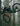 Santa Cruz green and orange Bike flying through the forest with both wheels in the air.